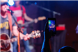Man Recording the Rock Show with His Phone