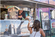 Woman Receiving a Food From a Food Truck