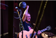 Guitarist Gesturing to the Audience with His Hat