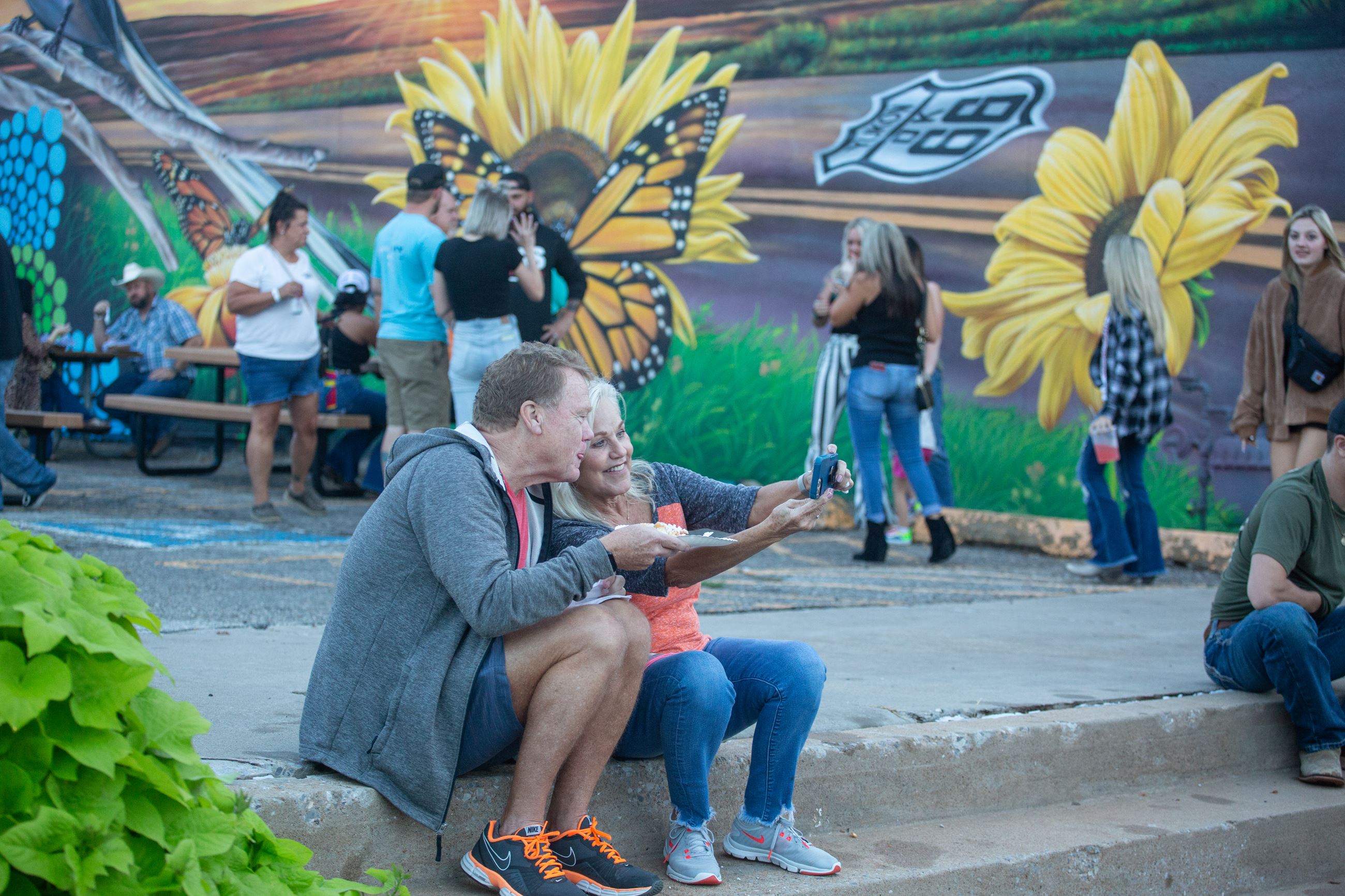 Couple takes selfie by Butterfly Mural at Rock the Route 2022