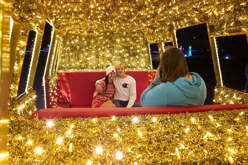 Young Couple Have Their Pictures Taken Inside a Carriage Light Display